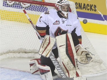 Calgary Hitmen's goalie Brendan Burke keeps his eye on the puck during WHL playoff action the Brandon Wheat Kings at the Saddledome in Calgary, on April 29, 2015.