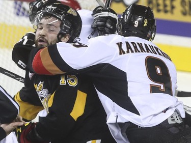 Brandon Wheat Kings' Peter Quenneville gets a bit of a headlock from Calgary Hitmen's Pavel Karnaukhov during WHL playoff action at the Saddledome in Calgary, on April 28, 2015.