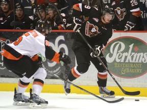 Calgary Hitmen centre Pavel Karnaukhov carries the puck into the offensive zone while Medicine Hat Tigers defenceman Tyler Lewington gives chase during Game 1 of the Eastern Conference semifinals Friday April 10, 2015.