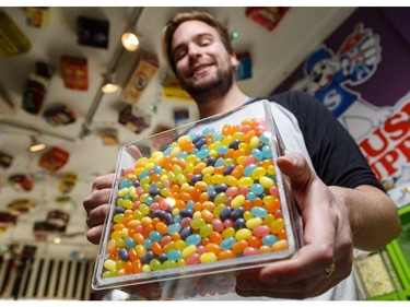 Matthew Hawes holds a container of jelly beans at Gummi Boutique in Kensington on Tuesday, April 21, 2015.