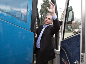 Alberta Premier Jim Prentice waves to supporters as leaves on his bus after announcing an election in Edmonton, on April 7, 2015.