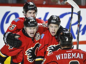 The Flames need a good does of this in order to end the series Friday:  Johnny Gaudreau, centre, celebrates a goal with teammates Sean Monahan, left, Jiri Hudler, and Dennis Wideman during Game 4 on Tuesday.