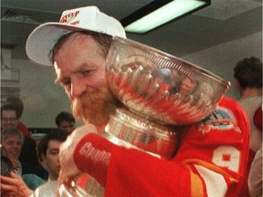 Calgary Flames' Lanny McDonald hugs the Stanley Cup after they beat the Montreal Canadiens in 1989. He, Joel Otto and Theo Fleury addressed the current Flames on Tuesday ahead of their playoff opener against Vancouver.