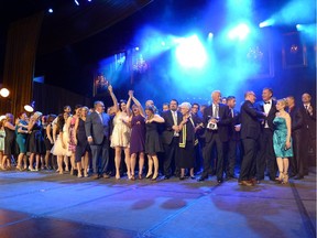 Morrison Homes celebrates on stage after winning the CHBA-Calgary Region  2014 Grand SAM Award for Builder of the Year, on April 18, 2015, at the Telus Convention Centre. Company chairman Al Morrison is holding the silver goose trophy.