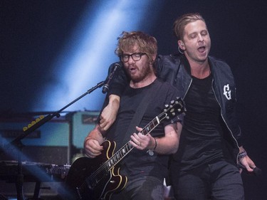 One Republic lead singer Ryan Tedder hangs off of Zach Filkins during their concert at the Saddledome in Calgary, on April 30, 2015.