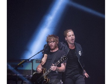 One Republic lead singer Ryan Tedder hangs off of Zach Filkins during their concert at the Saddledome in Calgary, on April 30, 2015.