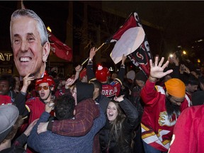 Calgary Flames fans hold up a cut out head of Calgary Flames head coach Bob Hartley walk on 17th Ave SW, aka. The Red Mile, after the Flames beat the Canucks in game six of the playoff's in Calgary, on April 25, 2015.