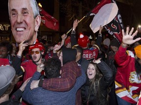 Calgary Flames fans hold up a cut out head of Calgary Flames head coach Bob Hartley walk on 17th Ave SW, aka. The Red Mile, after the Flames beat the Canucks in game six of the playoff's in Calgary, on April 25, 2015.