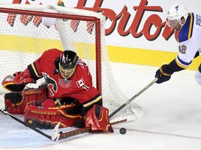 Calgary Flames goalie Jonas Hiller, left, blocks  St. Louis Blues' Chris Porter during their March 17 meeting.