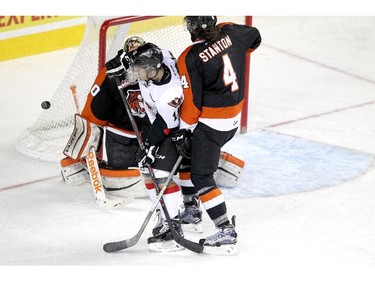 CALGARY, ; APRIL 12, 2015  -- Hitmen Beck Malenstyn gets sandwiched between Tigers goalie Marek Langhamer and Ty Stanton, 4, in the third period  in game two as the Calgary Hitmen played host to the Medicine Hat Tigers at the Saddledome on April 12, 2015. (Lorraine HJalte/Calgary Herald) For Sports story by . Trax # 00064111A