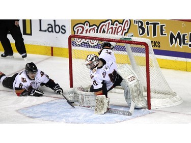 Hitmen Loch Morrison helps goalie Mack Shields stop the puck in the third period in game two as the Calgary Hitmen played host to the Medicine Hat Tigers at the Saddledome on April 12, 2015. Lorraine Hjalte/Calgary Herald