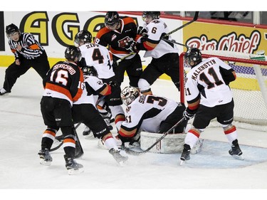 CALGARY, ; APRIL 12, 2015  --Hit men goalie Mack Shields manages to keep the puck covered up while being surrounded in the third period in game two as the Calgary Hitmen played host to the Medicine Hat Tigers at the Saddledome on April 12, 2015. (Lorraine HJalte/Calgary Herald) For Sports story by . Trax # 00064111A