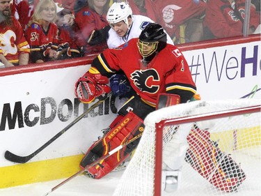 Calgary Flames goalie Jonas Hiller held up Vancouver Canucks right winger Derek Dorsett behind the net during first period NHL Game 3 playoff action at the Scotiabank Saddledome in Calgary on April 19, 2015.