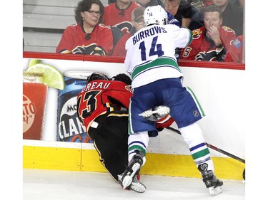 Calgary Flames left winger Johnny Gaudreau got run into the boards by Vancouver Canucks right winger Alexandre Burrows during third period NHL Game 3 playoff action at the Scotiabank Saddledome in Calgary on April 19, 2015. The Flames defeated the Canucks 4-2 to take a 2-1 lead in the best-of-seven series.