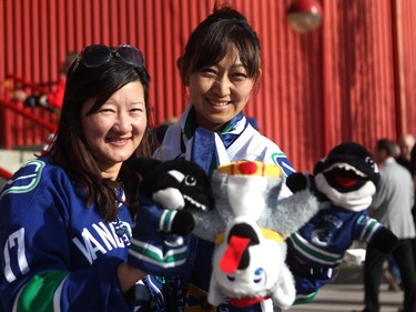 Vancouver hockey fans Helen Lo and Grace Chun, from Vancouver, got geared up for Game 4 of the playoffs between the Calgary Flames and the Vancouver Canucks at the Scotiabank Saddledome on April 21, 2015. The both had Canucks mascot Fin the Whale hand puppets which they were tormenting a Harvey the Hound puppet prior to the game.