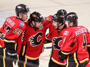 Calgary Flames players, from left, centre Sean Monahan, centre Jiri Hudler, left winger Johnny Gaudreau and defenceman Kris Russell celebrated after Hudler scored the Flames second goal of the game against the Vancouver Canucks during first period NHL playoff action in game 4 of the series at the Scotiabank Saddledome in Calgary on April 21, 2015.  (Colleen De Neve/Calgary Herald) (For Sports story by Scott Cruickshank) 00064432B SLUG: 0422-Flames Canucks Game 4