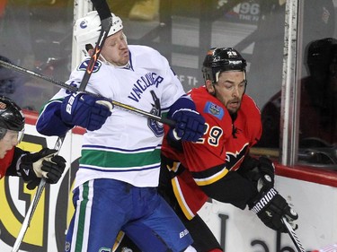 Calgary Flames defenceman Deryk Engelland and Vancouver Canucks right winger Derek Dorsett collided into the boards during first period NHL playoff action in game 4 of the series at the Scotiabank Saddledome in Calgary on April 21, 2015.