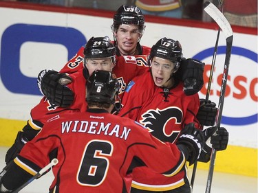 Calgary Flames left winger Johnny Gaudreau, right, celebrated his goal with teammates, from left, centre Jiri Hudler, centre Sean Monahan, and defenceman Dennis Wideman after opening the scoring against the Vancouver Canucks during first period NHL playoff action in game 4 of the series at the Scotiabank Saddledome in Calgary on April 21, 2015.