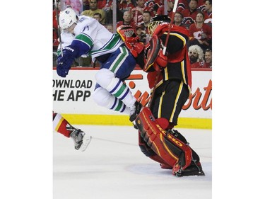 Vancouver Canuck Daniel Sedin gets a little air time in front of Flames goaltender Jonas Hiller during the Second period of NHL playoff  game 4 action at the Scotiabank Saddledome.
