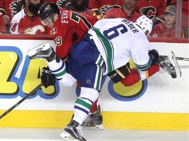 Calgary Flames left winger Michael Ferland was run into the boards by Vancouver Canucks defenceman Yannick Weber during second period NHL playoff action in game 4 of the series at the Scotiabank Saddledome in Calgary on April 21, 2015.