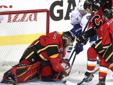 Calgary Flames goalie Jonas Hiller closed the door on Vancouver Canucks left winger Daniel Sedin as Flames defenceman Dennis Wideman provided some support during second period NHL playoff action in game 4 of the series at the Scotiabank Saddledome in Calgary on April 21, 2015.