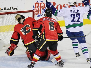Vancouver Canuck Daniel Sedin celebrates after the Canucks scored on Flames goaltender Jonas Hiller during the first period of NHL playoff  game 4 action at the Scotiabank Saddledome.