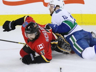 Vancouver Canuck Nick Bonino lands on Calgary Flame David Schlemko during third period action of NHL playoff  game 4 action at the Scotiabank Saddledome.