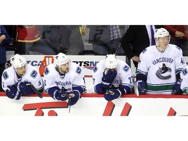 Members of the Vancouver Canucks, from left, defenceman Luca Sbisa, defenceman Christopher Tanev, centre Shawn Matthias and left winger Ronalds Kenins sat dejected on the Canucks bench in the final minute of the third period NHL playoff action in game 4 of the series at the Scotiabank Saddledome in Calgary on April 21, 2015. The Flames defeated the Canucks 3-1 to take a 3-1 lead in the best of 7 series.