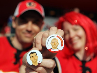 Colleen De Neve/ Calgary Herald CALGARY, AB --APRIL 22, 2015 -- Calgary hockey fans Matt Panelli, left, and his wife Diana Panelli showed off their playoff hockey fashion outside the Scotiabank Saddledome on April 21, 2015 prior to game 4 of the playoffs between Calgary and Vancouver. The couple have been collecting the popular player pins and showed off their TJ Brodie and Mark Giordano pins. (Colleen De Neve/Calgary Herald) (For City story by Val Fortney) 00064508A SLUG: 0422-Flames Fans Fashion