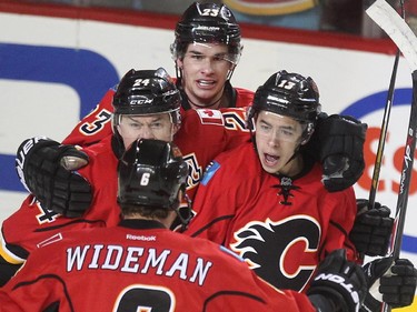Calgary Flames left winger Johnny Gaudreau, right, celebrated his goal with teammates, from left, centre Jiri Hudler, centre Sean Monahan, and defenceman Dennis Wideman after opening the scoring against the Vancouver Canucks during first period NHL playoff action in game 4 of the series at the Scotiabank Saddledome in Calgary on April 21, 2015.