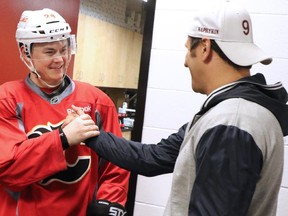 Former Calgary Flames forward Oleg Saprykin, right, chats with Jiri Hudler during a surprise visit to the Saddledome on Wednesday.