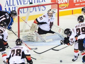 Calgary Hitmen goalie Mack Shields keeps his eyes on the puck as Kootenay Ice players converge on his crease during Game 7 on Monday.