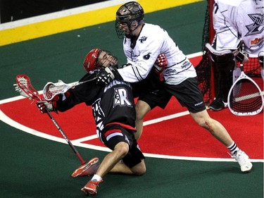 Calgary Roughnecks forward Shawn Evans got tossed to the turf by Edmonton Rush defenceman John Lintz during first half NLL action at the Scotiabank Saddledome on April 10, 2015.