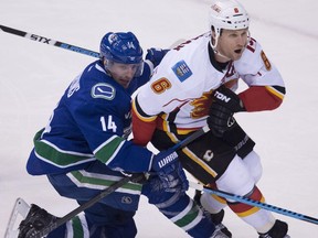Vancouver left winger Alex Burrows dogs Calgary defender Dennis Wideman during Game 1. The Canucks are clearly keying on the minute munchers of the Flames defence.