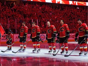 T.J. Brodie #7, Michael Ferland #79, Matt Stajan #18, David Jones #19 and Corey Potter #28 of the Calgary Flames line up for the singing of the national anthem prior to Game 4 of the Stanley Cup Playoffs at Scotiabank Saddledome on April 21, 2015 in Calgary, Alberta, Canada.