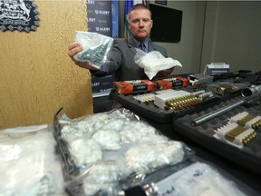 Staff Sgt. Keith Hurley with some of the drugs and firearms that were seized by ALERT and the Calgary Police Service.