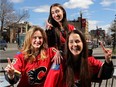 Morgan Gelinas, left, daughter of former Flames player Martin Gelinas, Alexa Lagadin and Hannah Lomas cheer on the young rookies on the Calgary Flames team on 17th Avenue, in Calgary, on April 20, 2015.