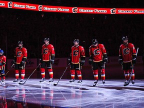 The starting line up for the Calgary Flames stands during the singing of the national anthem in Game Three of the Western Conference Semifinals during the 2015 NHL Stanley Cup Playoffs at Scotiabank Saddledome on May 5, 2015 in Calgary, Alberta, Canada.