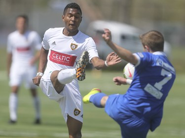Foothills FC player Jean Pierre Rodrigues-Lemos, left, kicks a shot before Puget Sound Gunner Adam Jones has a chance to catch the ball at Hellard Field in Calgary on Sunday, May 17, 2015. The Foothills FC under-23 team won over the Puget Sound Gunners, 2-1, in their home opening game.