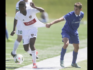 Foothills FC player Dominic Russo, left, is held back by the Puget Sound Gunners during his attempt to reach the net at Hellard Field in Calgary on Sunday, May 17, 2015. The Foothills FC under-23 team won over the Puget Sound Gunners, 2-1, in their home opening game.