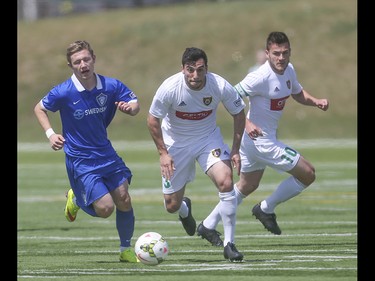 Foothills FC and Puget Sound Gunners players battle for control of the ball at Hellard Field in Calgary on Sunday, May 17, 2015. The Foothills FC under-23 team won over the Puget Sound Gunners, 2-1, in their home opening game.