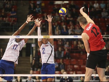 Team Cuba players wince in anticipation of Team Canada player Gavin Schmitt's spike at the Calgary Corral in Calgary on Sunday, May 17, 2015. Team Canada won over Team Cuba, 3-0, in the FIVB World League international men's volleyball tournament.