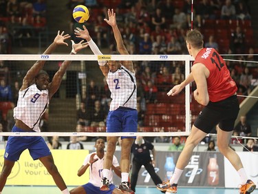 Team Cuba make an attempt to block Team Canada player Gavin Schmitt's spike at the Calgary Corral in Calgary on Sunday, May 17, 2015. Team Canada won over Team Cuba, 3-0, in the FIVB World League international men's volleyball tournament.