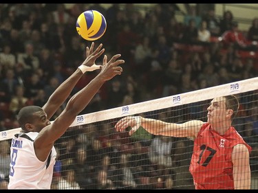 Team Cuba player Livan Osoria Rodriguez, left, just misses a spike by Team Canada player Graham Vigrass by mere centimetres at the Calgary Corral in Calgary on Sunday, May 17, 2015. Team Canada won over Team Cuba, 3-0, in the FIVB World League international men's volleyball tournament.