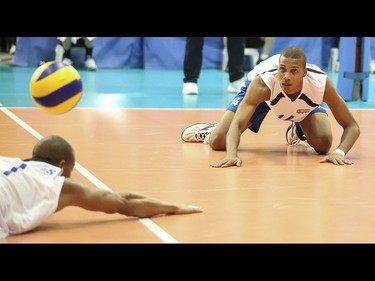 Team Cuba players dive towards the ball in an attempt to extend a long volley between themselves and Team Canada at the Calgary Corral in Calgary on Sunday, May 17, 2015. Team Canada won over Team Cuba, 3-0, in the FIVB World League international men's volleyball tournament.