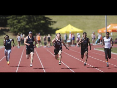 Donovan Sladek, centre, takes the lead in the 100 metre boys intermediate dash at the Foothills Athletic Park in Calgary on Saturday, May 23, 2015. Calgary's high school track and field athletes competed Saturday in the CSHAA championships.