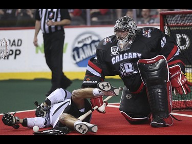 Edmonton Rush player Jarrett Davis, left, is knocked into the Roughneck net at the Scotiabank Saddledome in Calgary on Saturday, May 23, 2015. The Calgary Roughnecks led the Edmonton Rush, 9-7, in the first half of game two of the National Lacrosse League west division final.