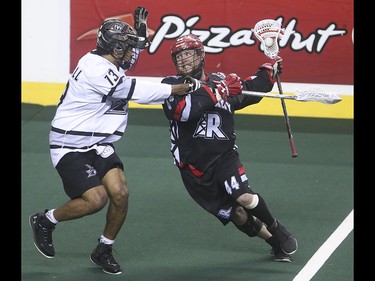 Roughneck forward Dane Dobbie, right, powers through Edmonton Rush defence Jeff Cornwall at the Scotiabank Saddledome in Calgary on Saturday, May 23, 2015. The Calgary Roughnecks led the Edmonton Rush, 9-7, in the first half of game two of the National Lacrosse League west division final.