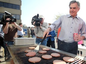 PC leader Jim Prentice flipped some burgers as he met with supporters of Linda Johnson at her campaign office as he wrapped up his campaigning during the provincial election on May 4, 2015.