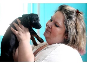 Jody Graves, a client of Calgary Urban Projects, holds her Dachshund Chihuahua cross Izzy on Monday May 25, 2015.